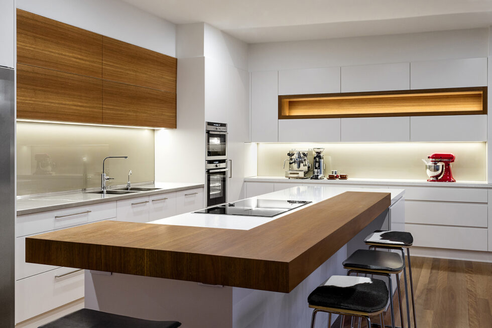 Luxury contemporary kitchen with custom timber joinery, stone island bench, integrated appliances, and architectural lighting in Adelaide, South Australia.