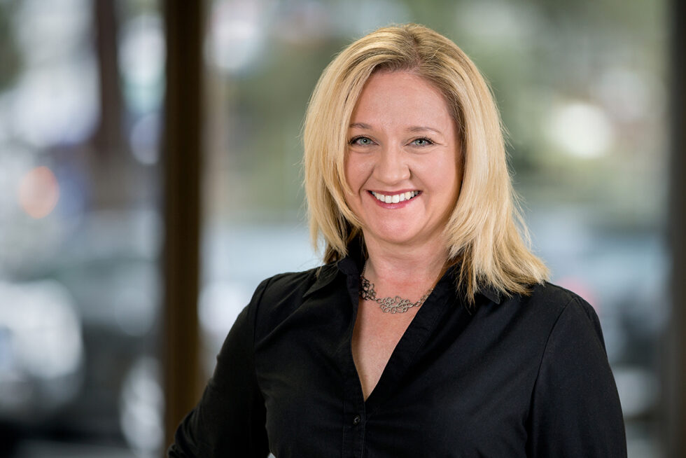 Professional headshot of a smiling businesswoman photographed in a contemporary office using studio lighting in Adelaide, South Australia.