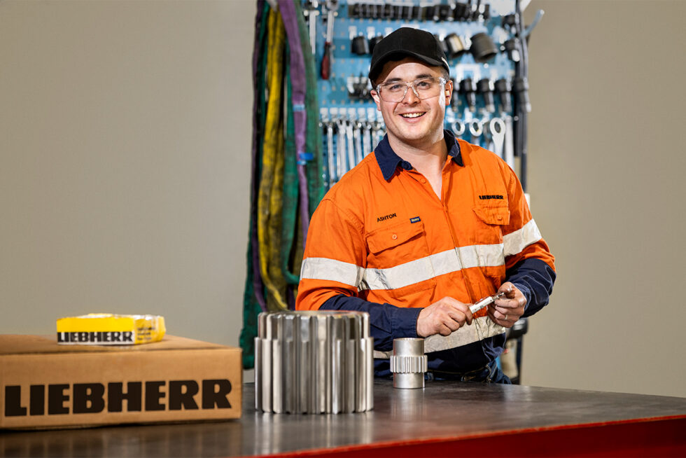 Professional workplace portrait of a technician assembling engineering components in a modern industrial workshop in Adelaide.