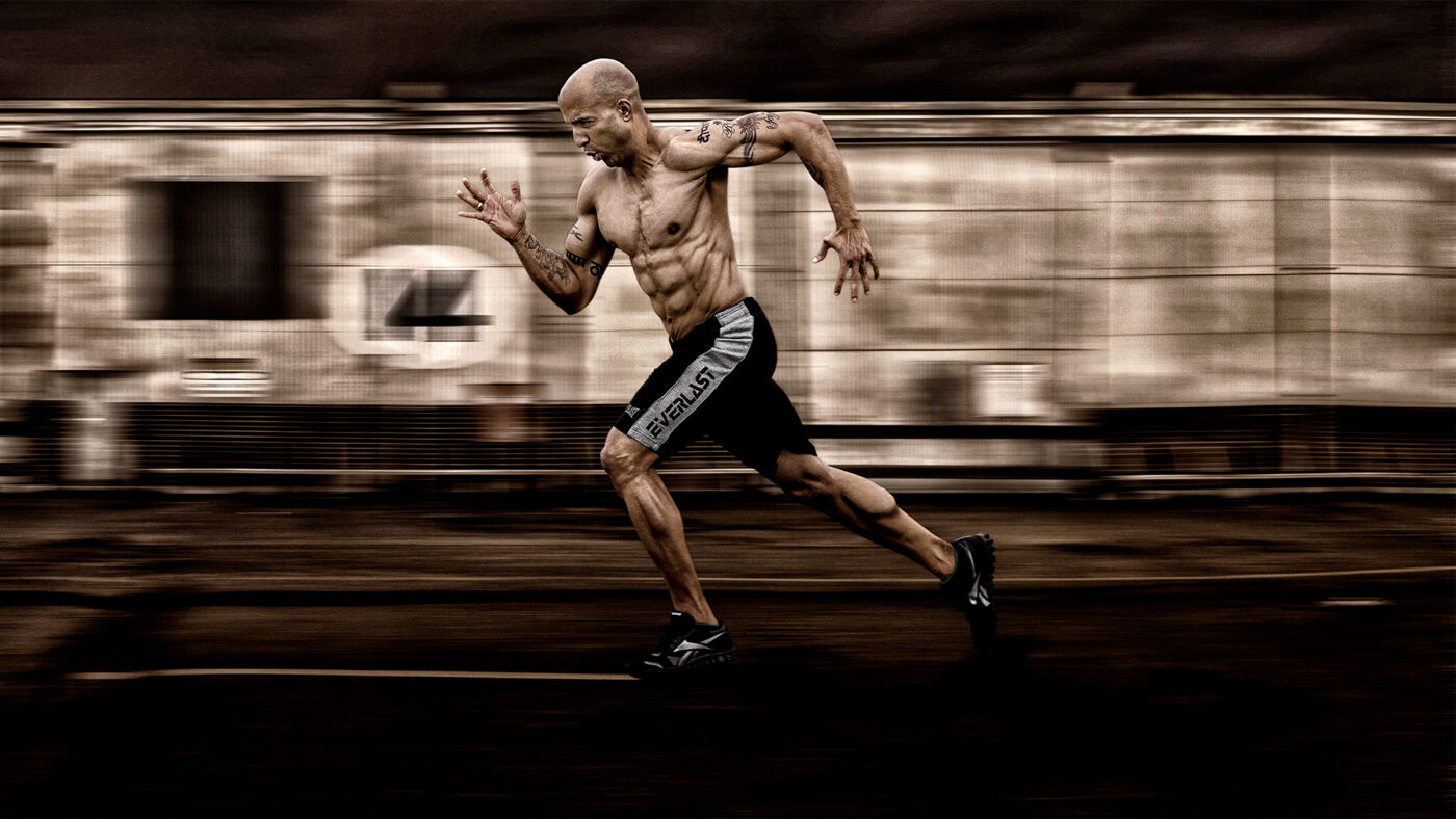 Dynamic fitness portrait of an athlete sprinting with motion blur, photographed in Adelaide by commercial and portrait photographer John Nieddu.