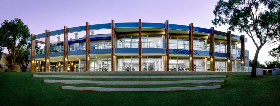 Twilight panoramic architectural photograph of a contemporary education building with illuminated interiors in Adelaide, South Australia.