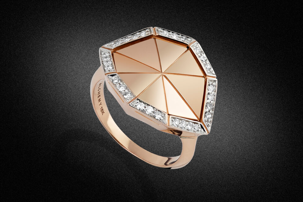 Professional product photograph of a contemporary rose gold designer ring with geometric styling and diamond accents on a black background.
